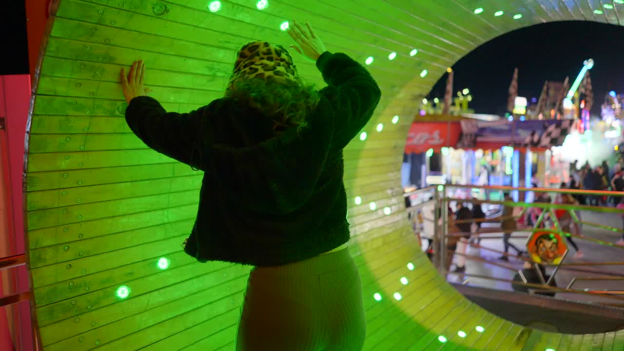 Woman in a Tunnel at a Nighttime Amusement Park