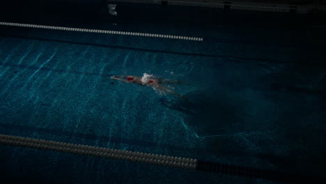 una nadadora haciendo estilo libre en una piscina cubierta