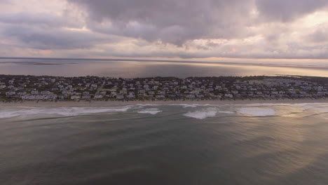 wide rising drone shot of beach houses on the coast on the outer banks of north carolina