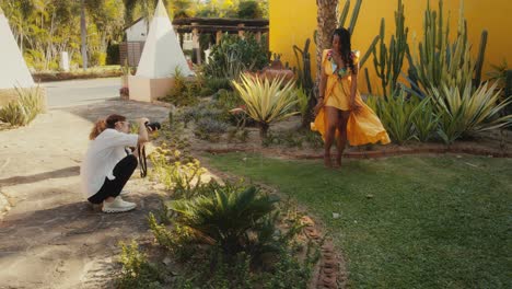 photographer capturing a model in a yellow dress in a tropical garden