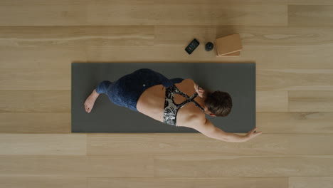 Vista-Superior-De-Una-Mujer-De-Yoga-Practicando-Una-Intensa-Pose-De-Estiramiento-Lateral-En-Un-Estudio-De-Ejercicios-Disfrutando-De-Un-Estilo-De-Vida-Saludable,-Practicando-Meditación-En-Una-Colchoneta-De-Ejercicios.