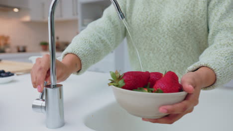 Hands-of-woman-cleaning-strawberry-with-water