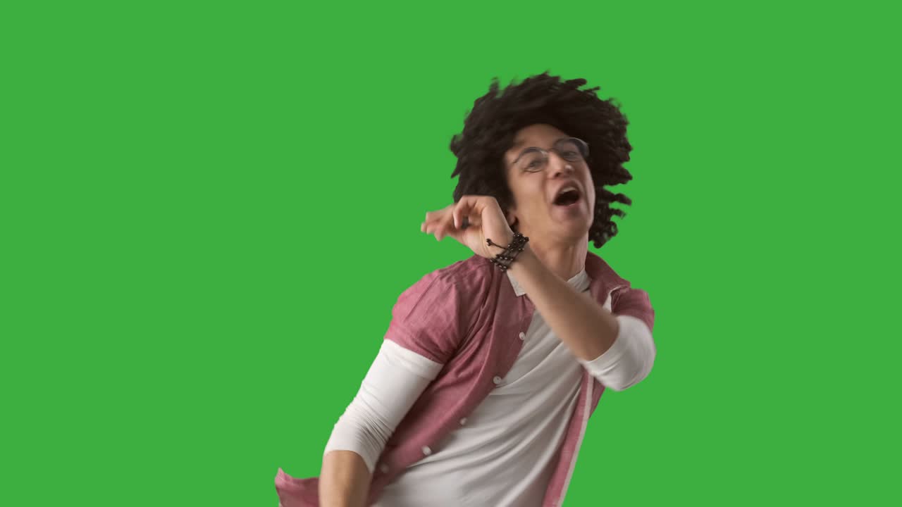 Excited man dancing over green background