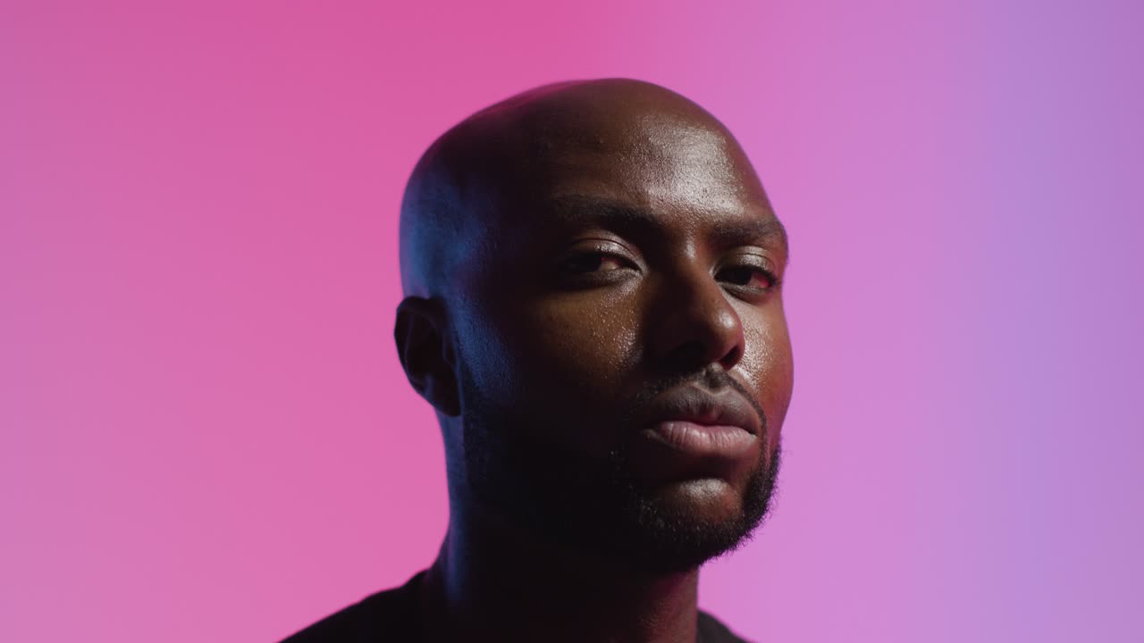 분홍색 빛을  ⁇  배경 에 스포츠 베스트 를 입은 남성 운동 선수 의 스튜디오 초상화 촬영