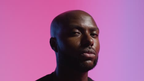 retrato de estudio de un atleta masculino con chaleco deportivo contra un fondo iluminado de color rosa