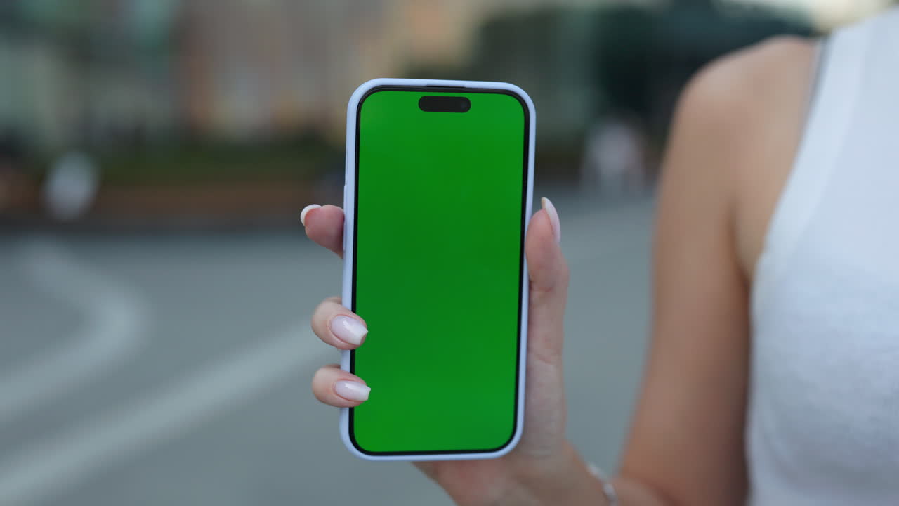 Smartphone with green screen held in hand