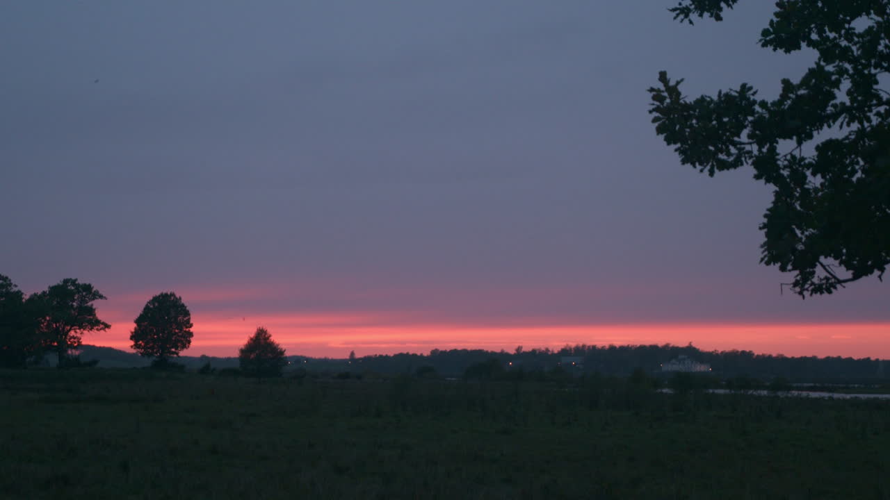 Herabfallende Blätter vor einem wunderschönen roten Sonnenuntergang