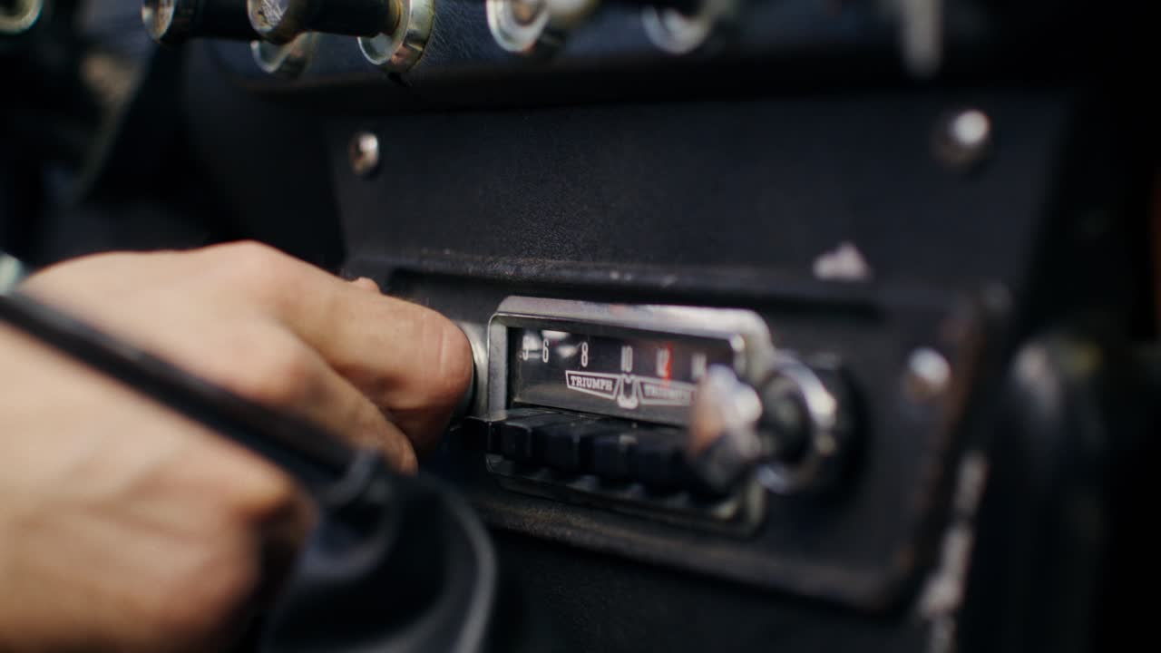 Person adjusting vintage car radio