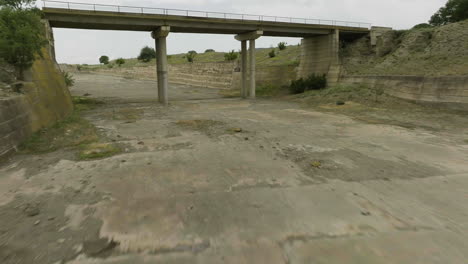 empty concrete dam sluice below bridge of dali mta reservoir, georgia