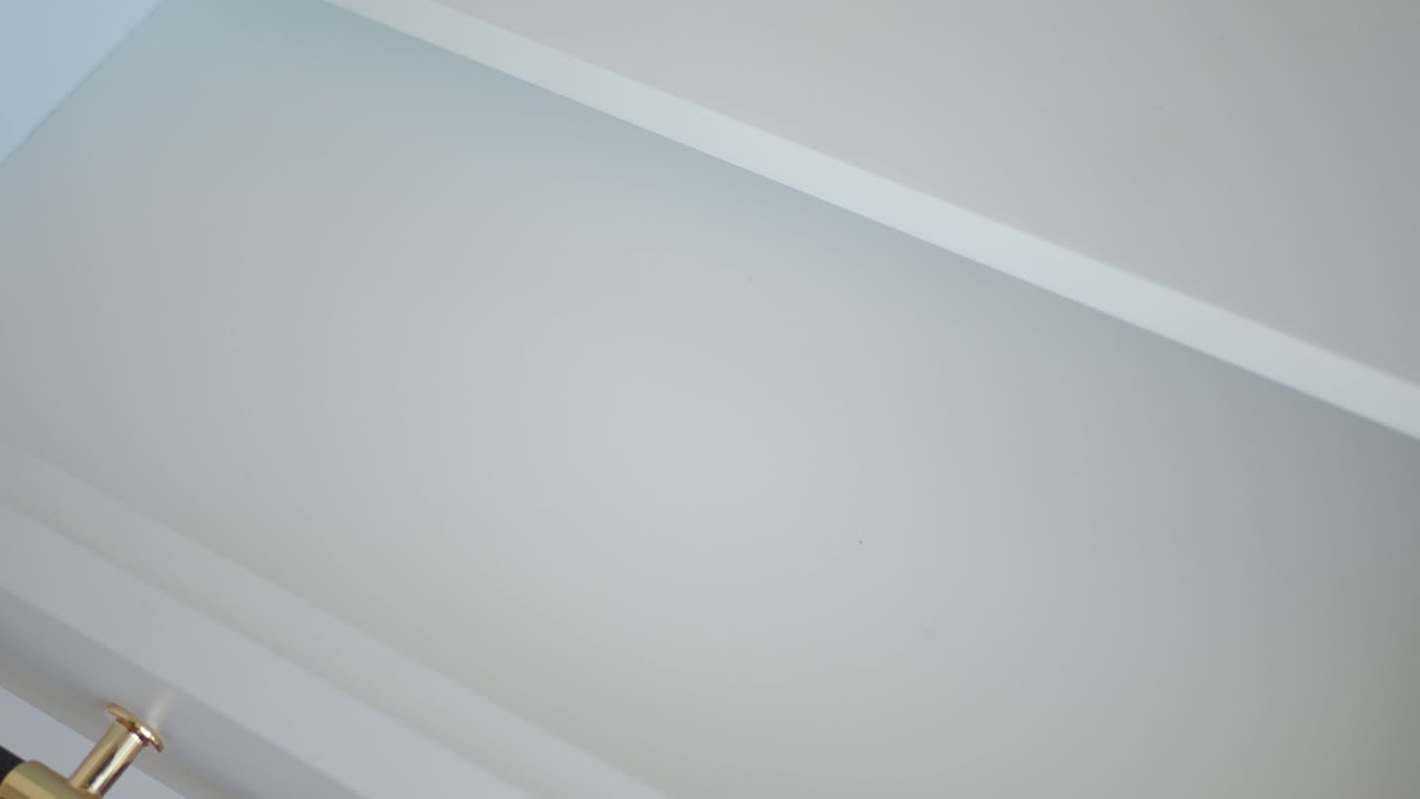 cerca de una mano abriendo un cajón de gabinete negro y dorado