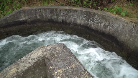 water swirl in canal flowing and splashing water in cold river.