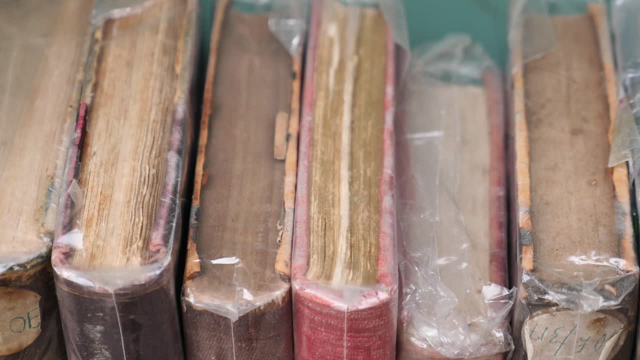 A close-up shot of a stack of old, bound books