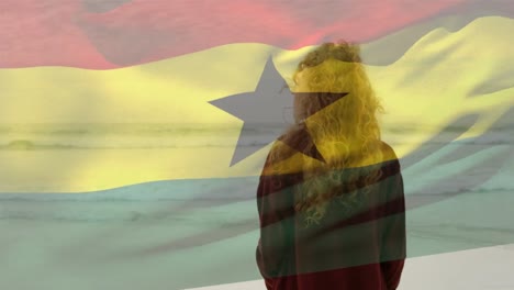 Animation-of-flag-of-ghana-over-caucasian-woman-at-beach