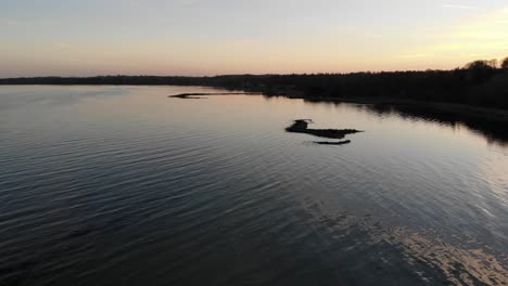 Luftaufnahme,-Die-über-Das-Meer-In-Nykøbing-Bugt-Fliegt,-Mit-Schwimmenden-Und-Fliegenden-Seevögeln-Bei-Einem-Wunderschönen-Sonnenuntergang