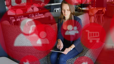 digital icons against woman using digital tablet
