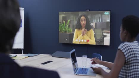 Diverse-business-people-on-video-call-with-african-american-female-colleague-on-tv-screen