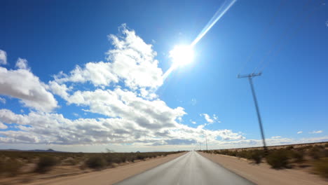 conduciendo hacia el oeste hacia la luz del sol y el paisaje nuboso sobre el desierto de mojave - hiperlapso de punto de vista