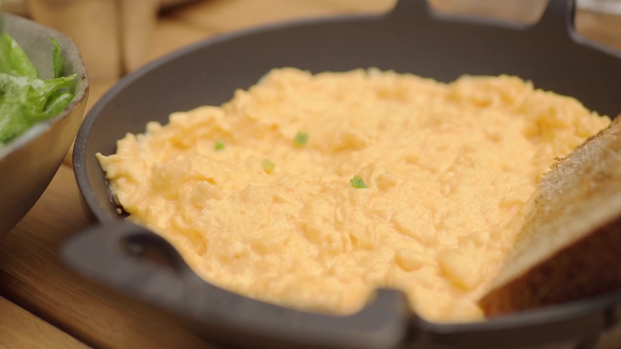 Scrambled Eggs Served in a Cast Iron Skillet with Toast