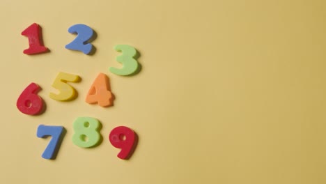 Studio-Overhead-Shot-Of-Plastic-Numbers-Arranged-In-Order-On-Yellow-Background-2