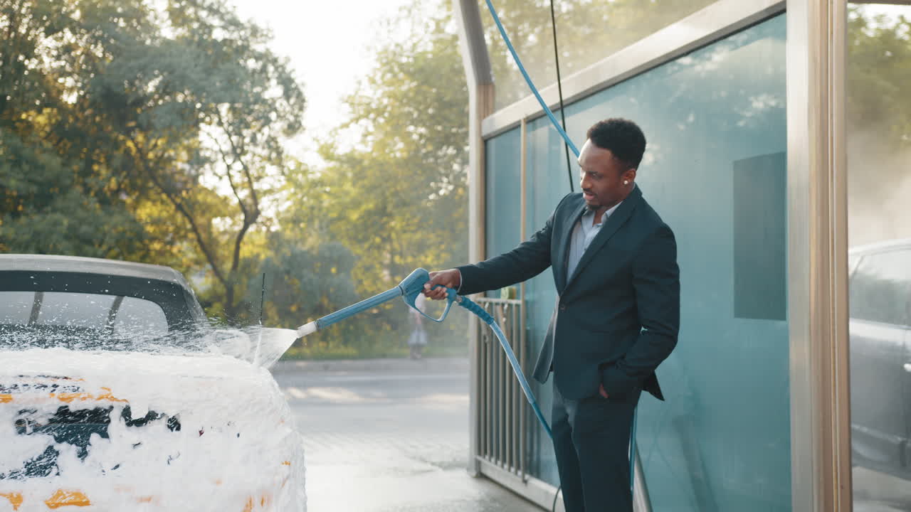 hombre lavando un coche en un lavado de coches automático