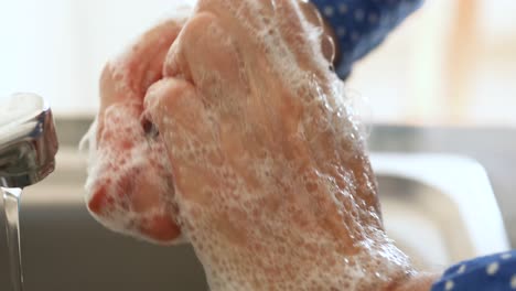 Caucasian-woman-washing-her-hands-with-soap-at-home