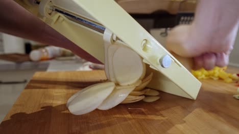 close up on slicing fresh potato on slicing board