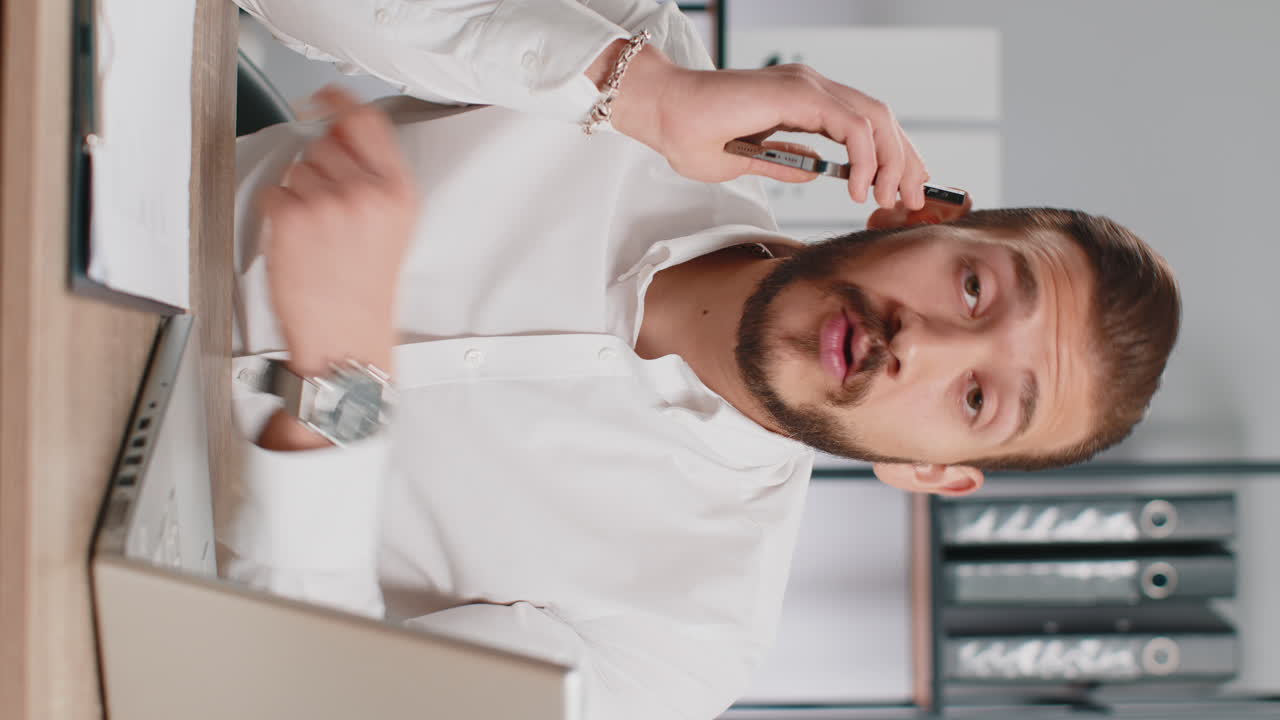 Young business man showing smartphone asking to make telephone conversation gesturing call me sign