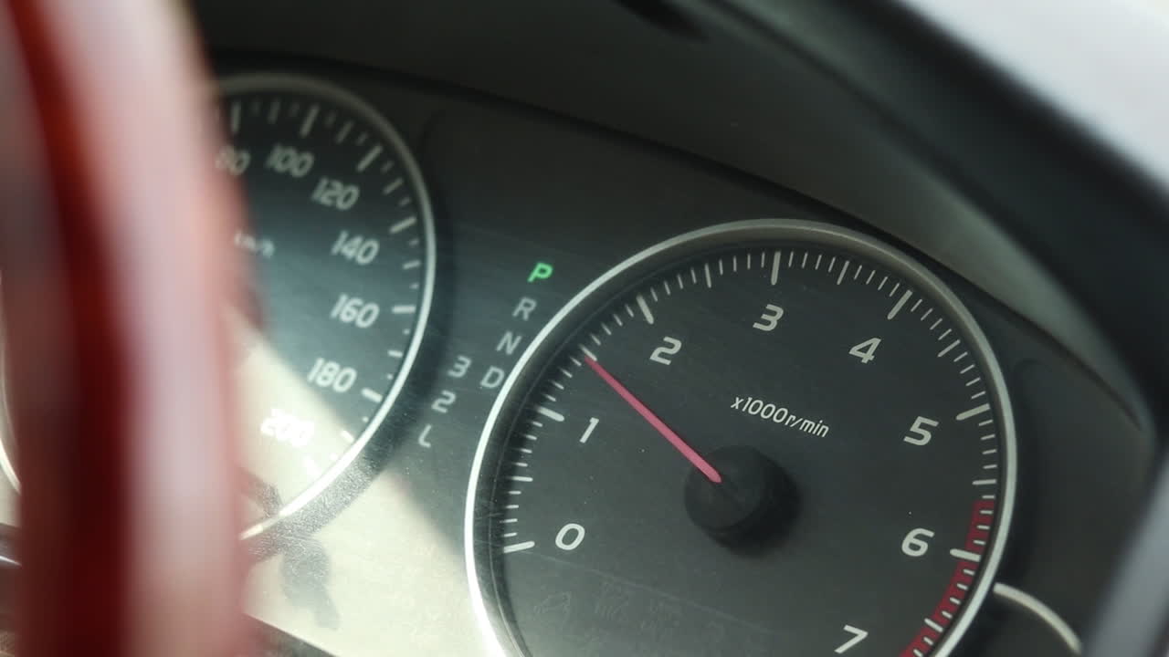 Close up of car dashboard with flashing trafficator lights and the engine revving. Double small illuminated hazard pointer light blinking together
