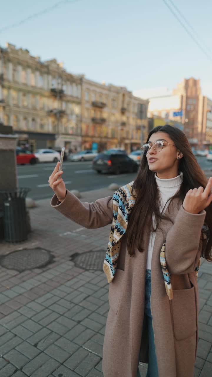 mujer tomando una selfie en una calle de la ciudad