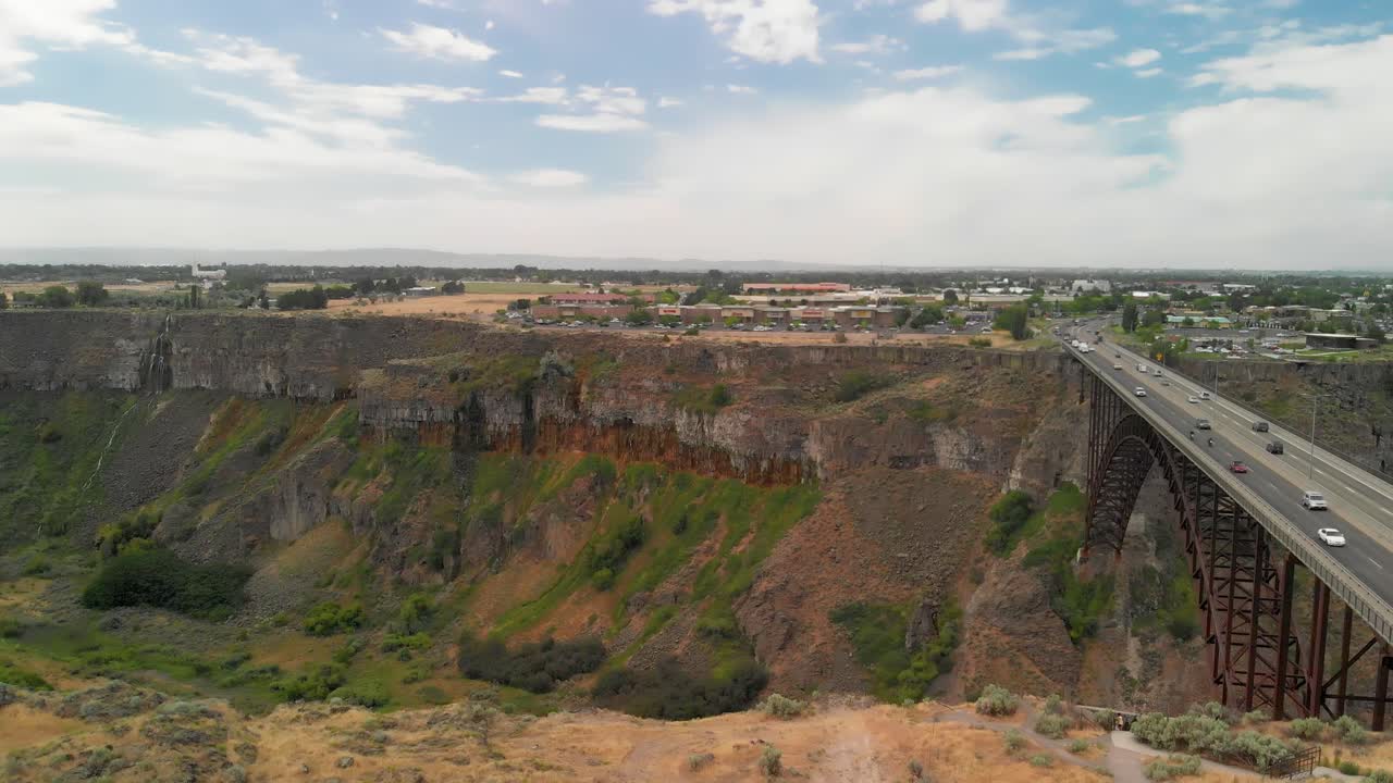 Slow downward aerial tilt towards the Snake River Canyon with the Perrine Memorial Bridge in Twin Falls, Idaho during the summer