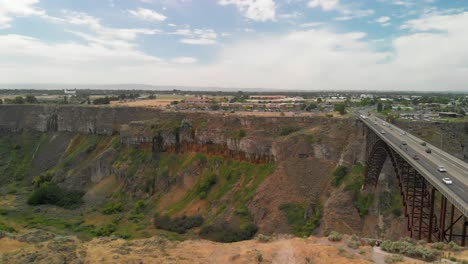 Inclinación-Aérea-Descendente-Lenta-Hacia-El-Cañón-Del-Río-Snake-Con-El-Puente-Conmemorativo-De-Perrine-En-Twin-Falls,-Idaho-Durante-El-Verano