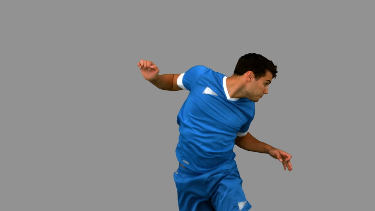 Man heading a football on grey screen