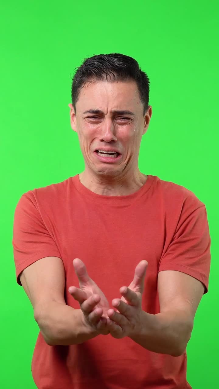 Man crying in front of green screen