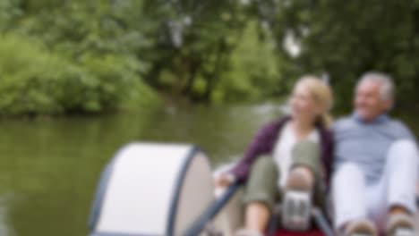 blurred couple in pedal boat on river