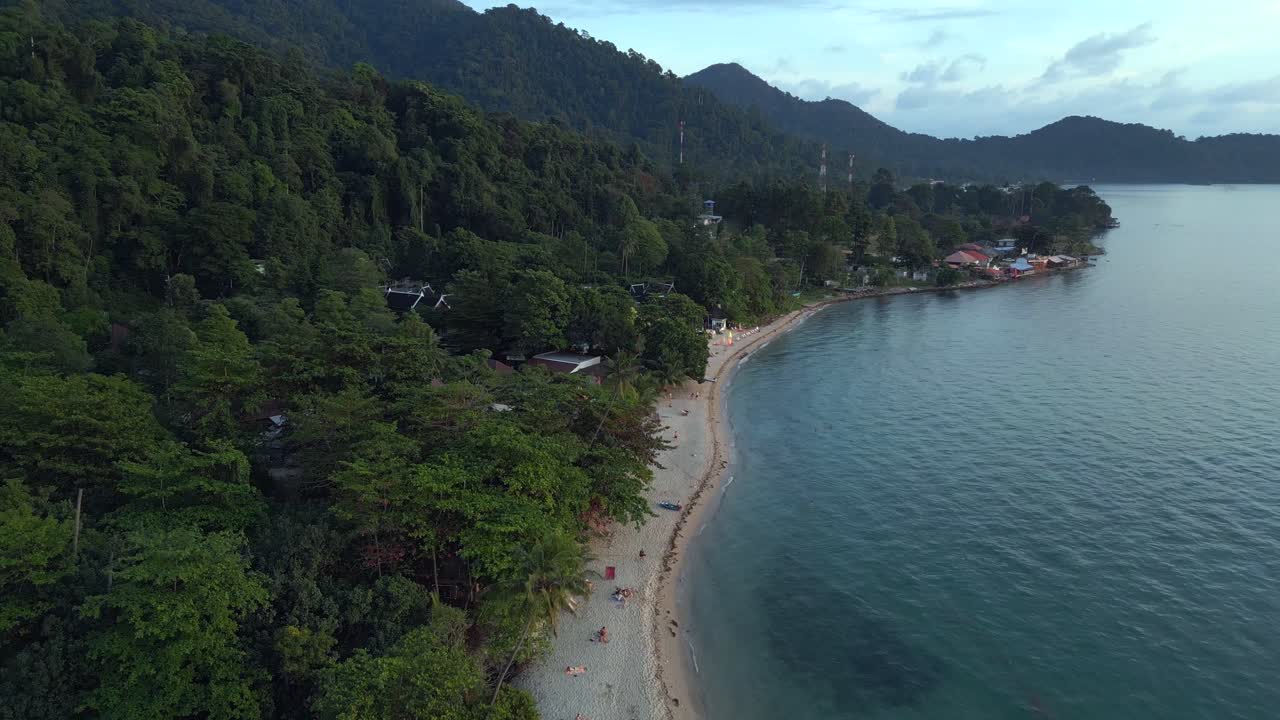 larga y estrecha playa de arena detrás de la jungla y las montañas