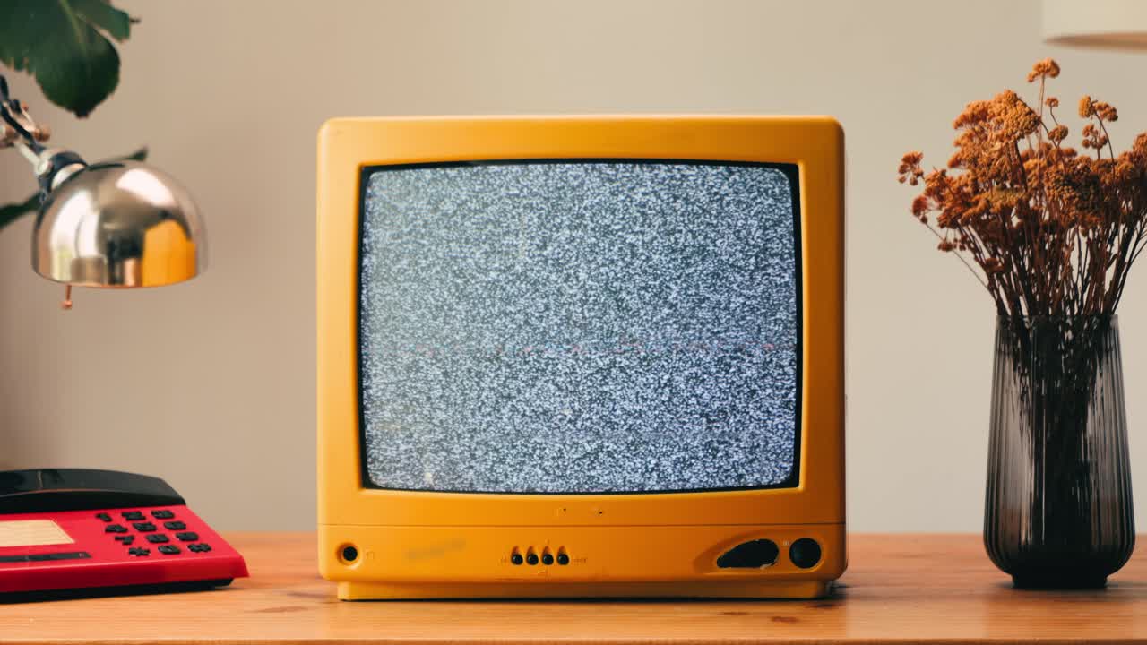 TV retrò, televisione vintage. In un'ambientazione nostalgica, un televisore retrò mostra grana sullo schermo, dispositivo per una spaventosa notte di Halloween, ottimo per chroma key e green screen. Filmato 4K di alta qualità.