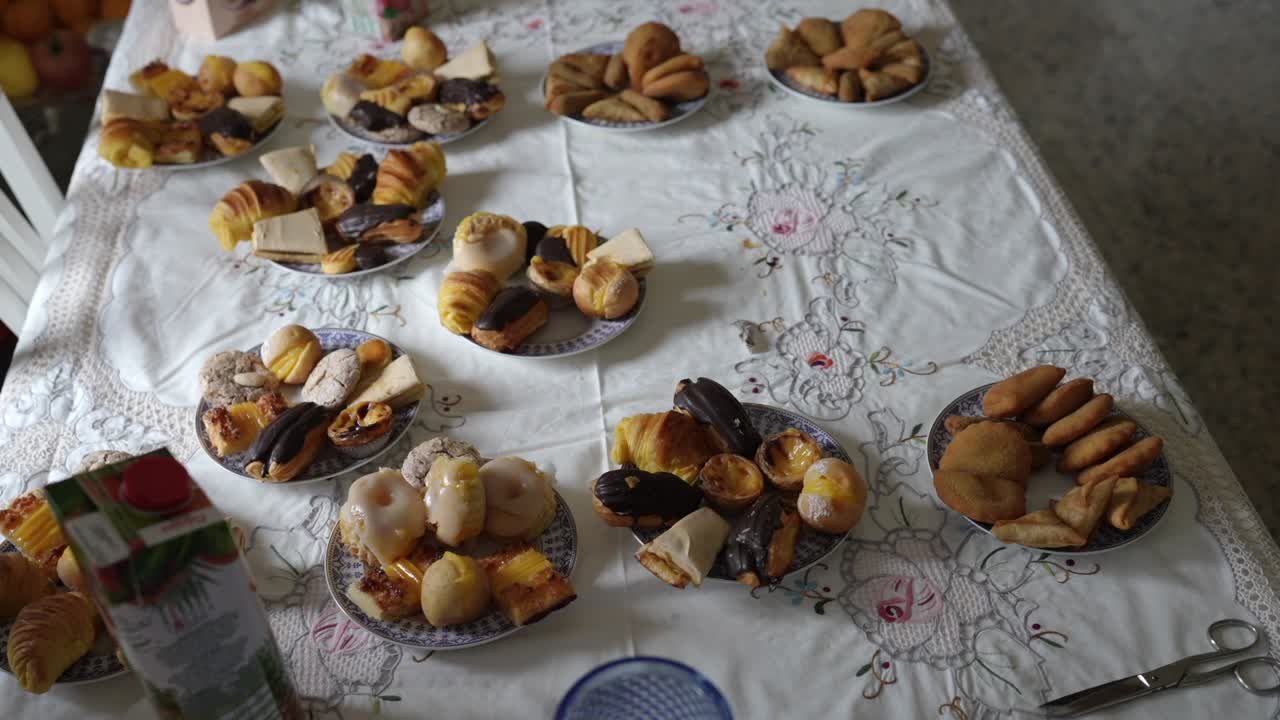 Overhead view of table spread with plates of mixed pastries, croissants and cookies