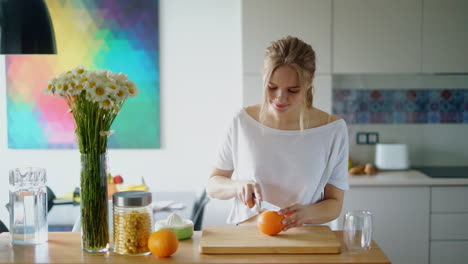 Mujer-Sana-Cortando-Naranja-Sobre-Tabla-De-Madera.-Preparando-El-Desayuno-De-La-Mañana