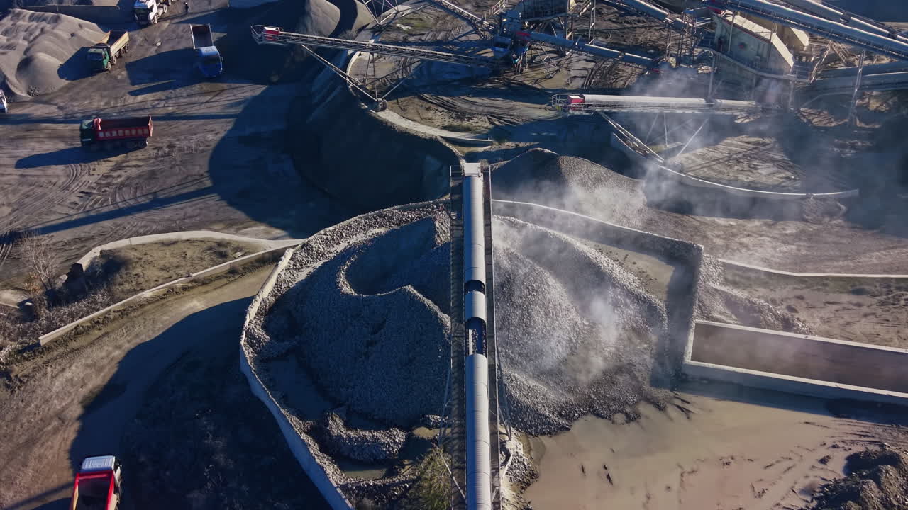 Industrial site captures dynamic energy of materials being processed under bright sunlight near modern facilities with complex machinery and landscapes