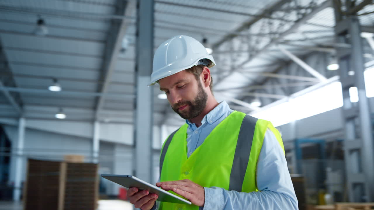 retrato de un empleado de la fábrica comprobando la tableta analizando el suministro de producción sonriendo