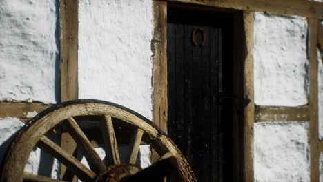 old wood wheel and black door at white house