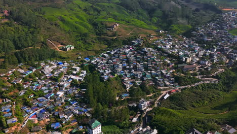 aerial pan shot overlooking colorful homes in munnar hill station, in sunny india