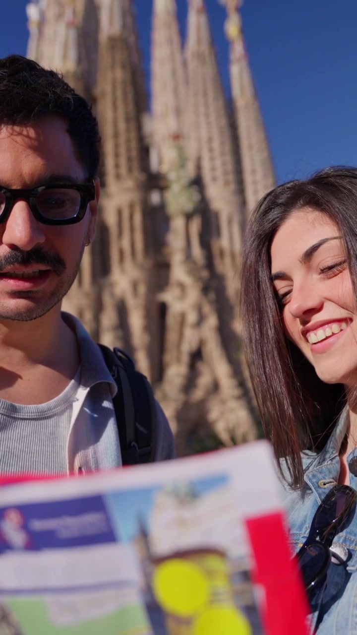 Jovem casal olhando um mapa em frente à Sagrada Família