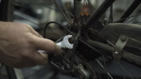 Ein-Fahrradmechaniker-Zieht-Die-Hinterradmutter-Fest