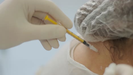 un médico que administra inyecciones de botulino a un paciente como tratamiento para el bruxismo y la espasticidad. el entorno clínico hace hincapié en la profesionalidad y la experiencia médica
