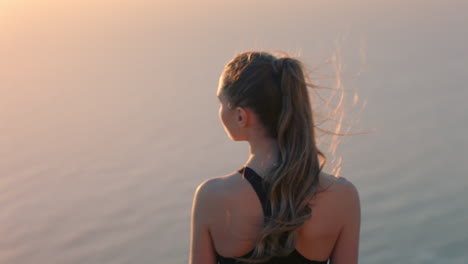 Frau-Auf-Dem-Berggipfel-Mit-Blick-Auf-Die-Schöne,-Ruhige-Aussicht-Auf-Das-Meer-Bei-Sonnenuntergang.-Mädchen-Steht-Am-Rand-Einer-Klippe-Und-Genießt-Die-Freiheit-Und-Denkt-über-Die-Reise-Zum-Gipfel-Nach