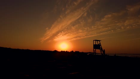 lifeguard tower silhouetted by the sunset