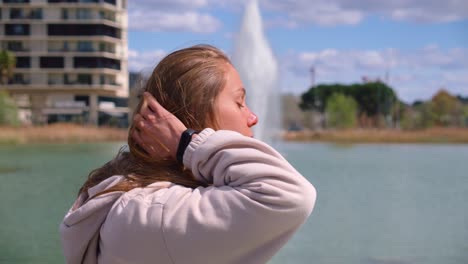 een meisje staat op een brug en haar haar komt over haar gezicht
