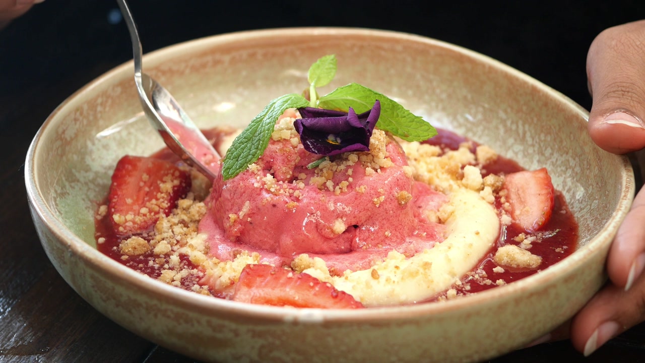 Scooping Delicious Strawberry Ice Cream Dessert with Fresh Fruit and Crumble