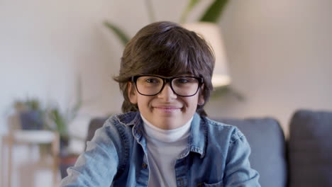 portrait shot of friendly hispanic boy in glasses